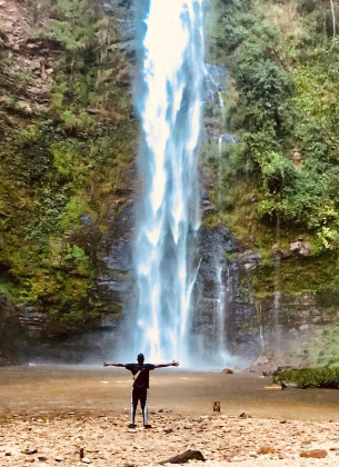 man hugging a waterfall