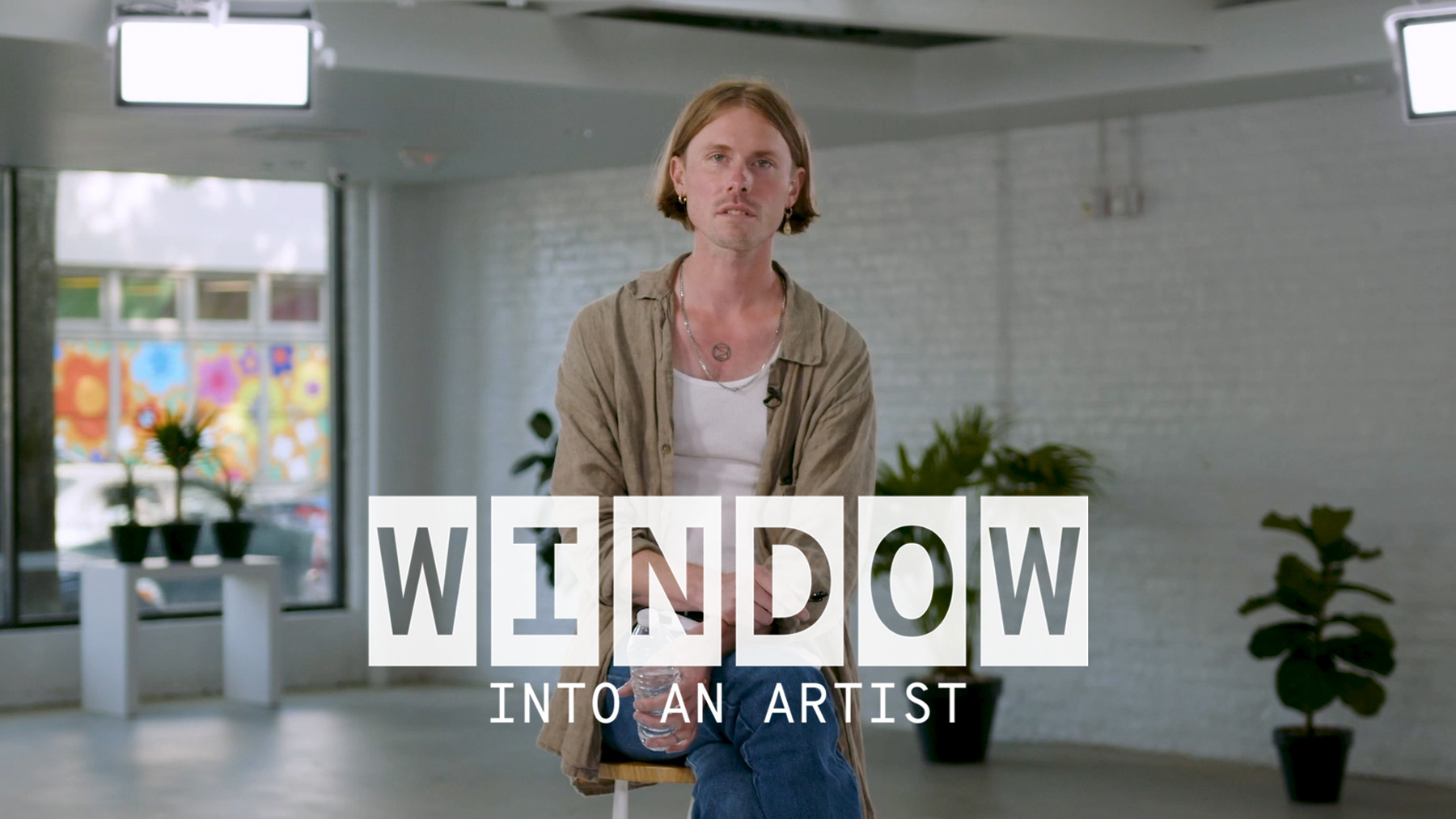 Ryan Gustafson of The Dead Tongues sitting on a bar stool. Text reads, ‘Window Into An Artist’