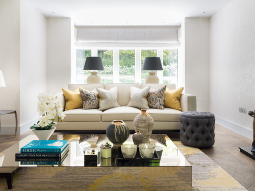 Spacious living room with a large white sofa and a mirrored coffee table with ornate candles on top Skype background