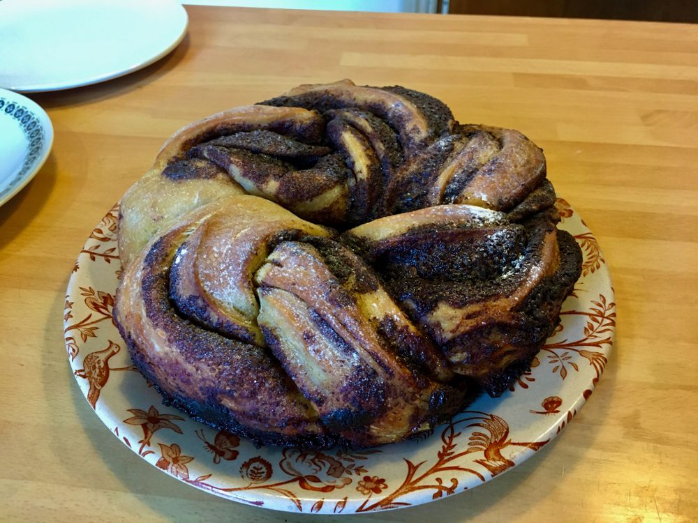 A huge circular, chocolate babka bread on a plate.
