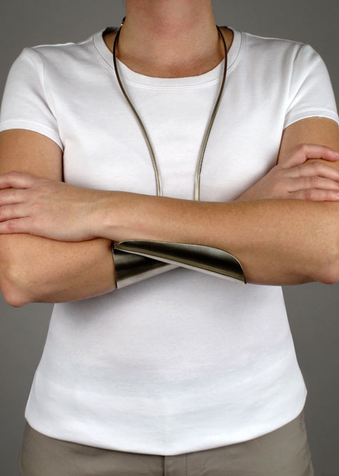 A model wears a "crossed arms" necklace—wiring hangs from the neck, and two half-cupping splints support crossed overlapping arms.