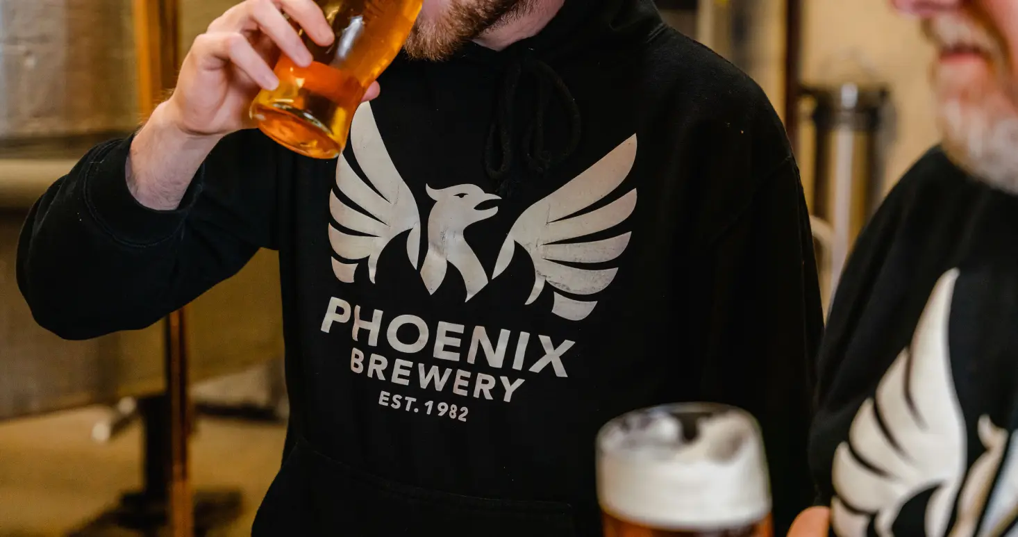 Close up of someone enjoying a pint of Phoenix Brewery beer
