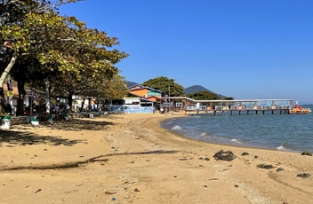 Vista da pequena faixa de areia com trapiche/restaurante característico da região.