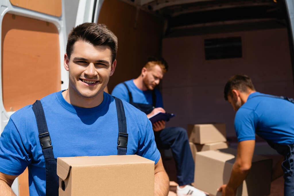 professional team movers loading cardboard boxes