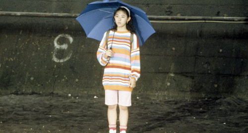 A screenshot of Takako standing with an open umbrella from the movie 'A Scene at the Sea'.