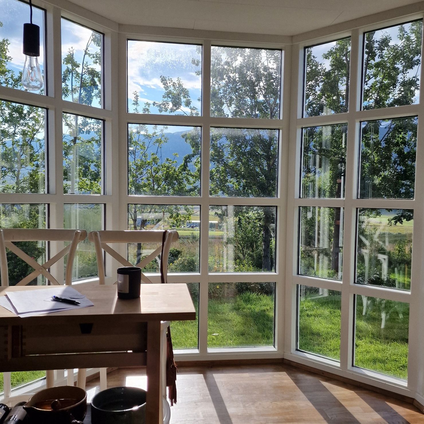 Große Panoramafenster öffnen den Blick vom Wohnbereich ins Grüne
