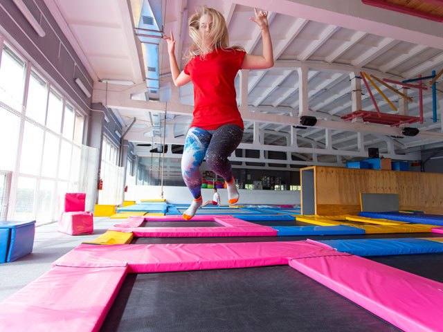 A woman jumping in a trampoline park alone
