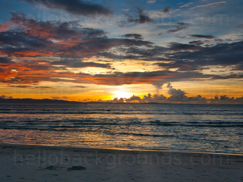 Ocean sunset on a sandy beach with dramatic cloudy sky Skype background
