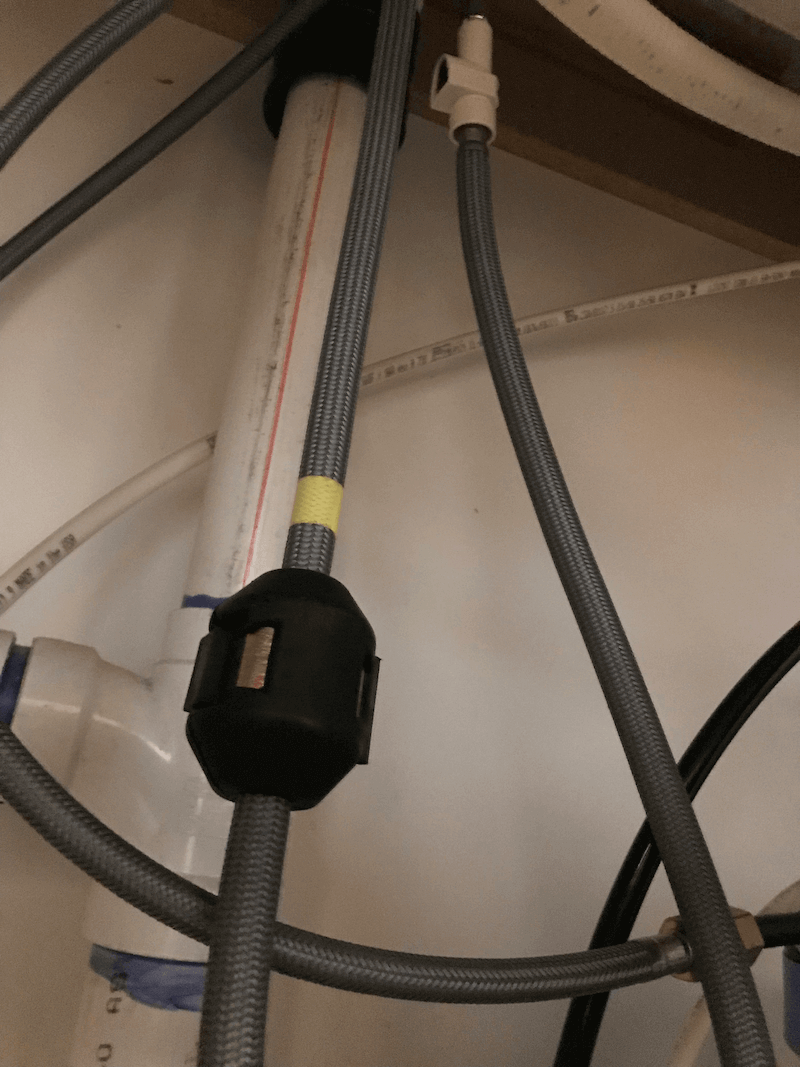 Under a sink a faucet hose is untangled