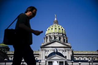 Man walks in front of Pennsylvania state capitol Man walks in front of Pennsylvania state capitol
