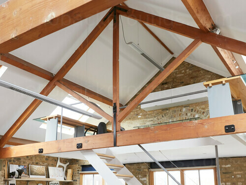 Multi-level loft style workspace featuring exposed London Brick behind glass and wood desks  Zoom background
