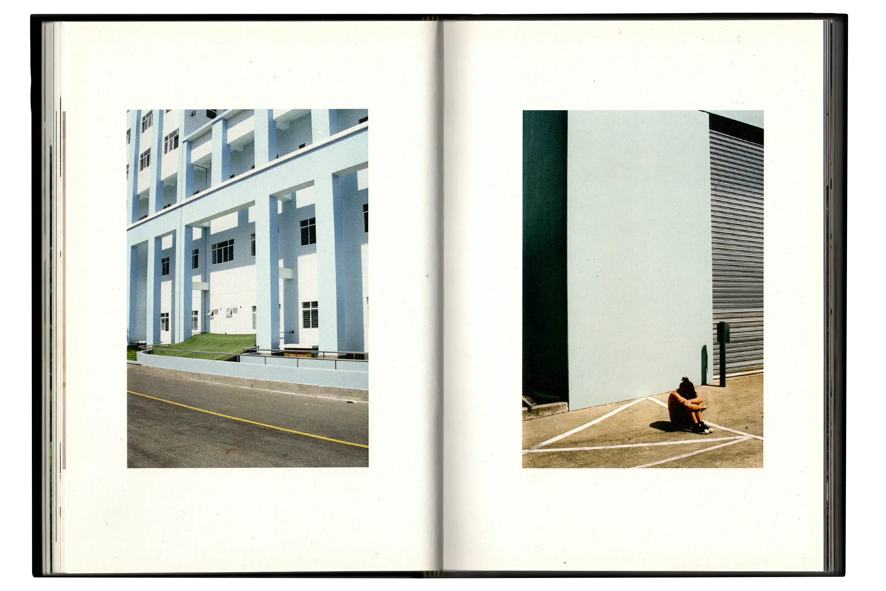 Imperfect Photo Book - left page image shows large blue building, right page image shows woman sitting with head down and arms crossed on floor in front of blue building
