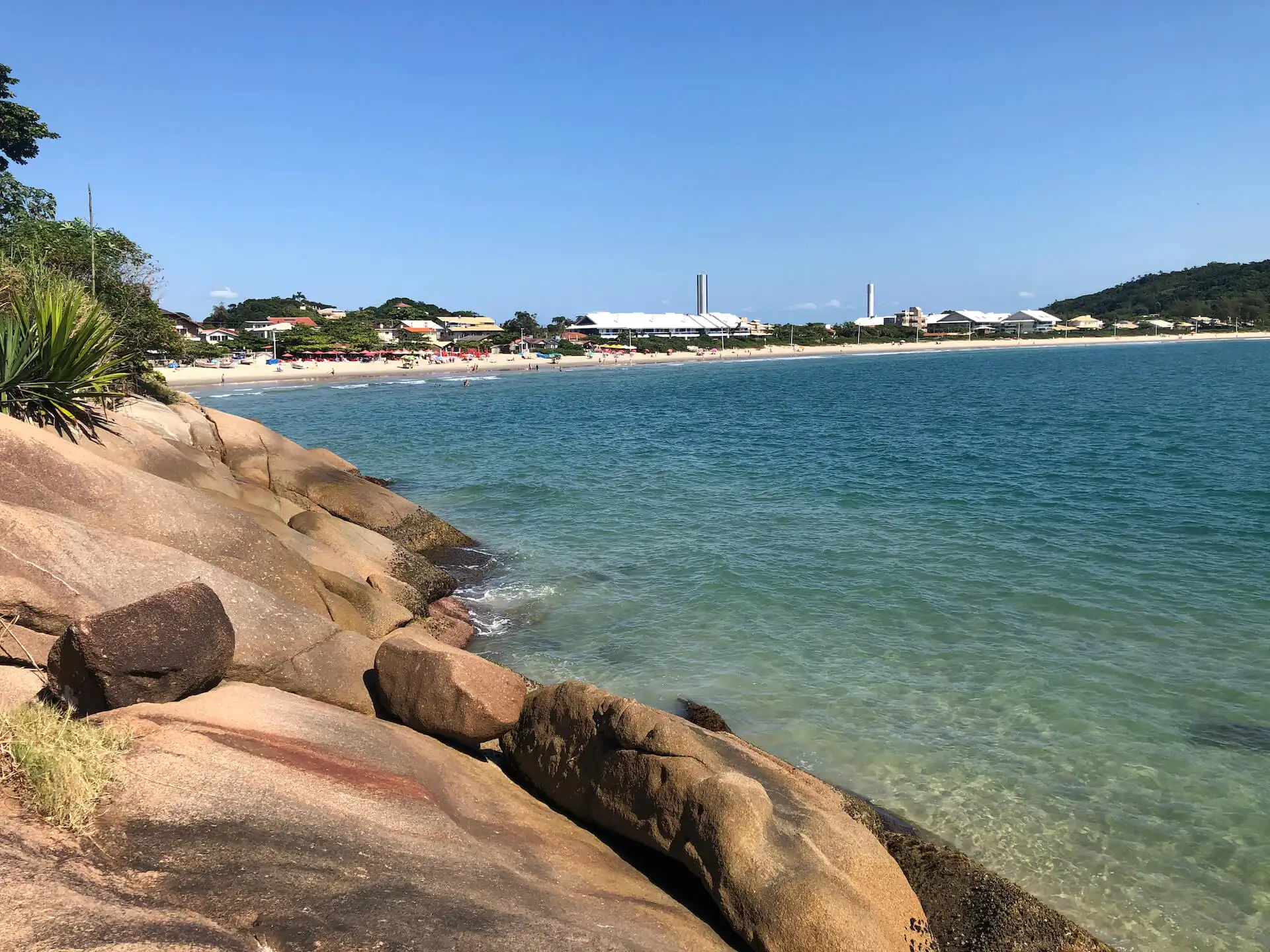 Vista das pedras da lagoinha do norte com mar a esquerda e a faixa de area ao fundo.