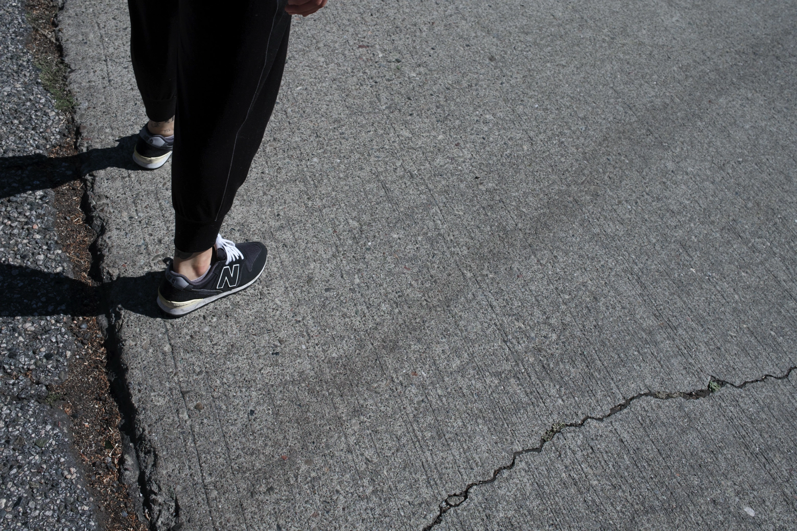 A person stands on a cracked pavement