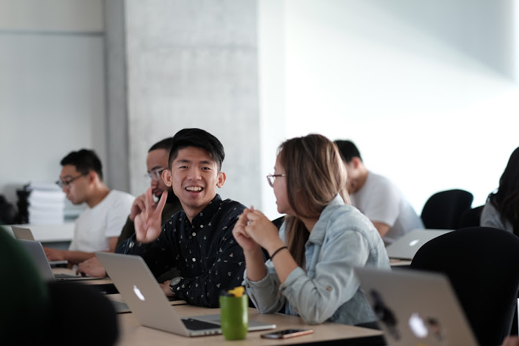 Telus attendees during the workshop. One of them is looking at the camera with a big grin and a peace sign.