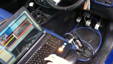 A laptop hooked up to a car