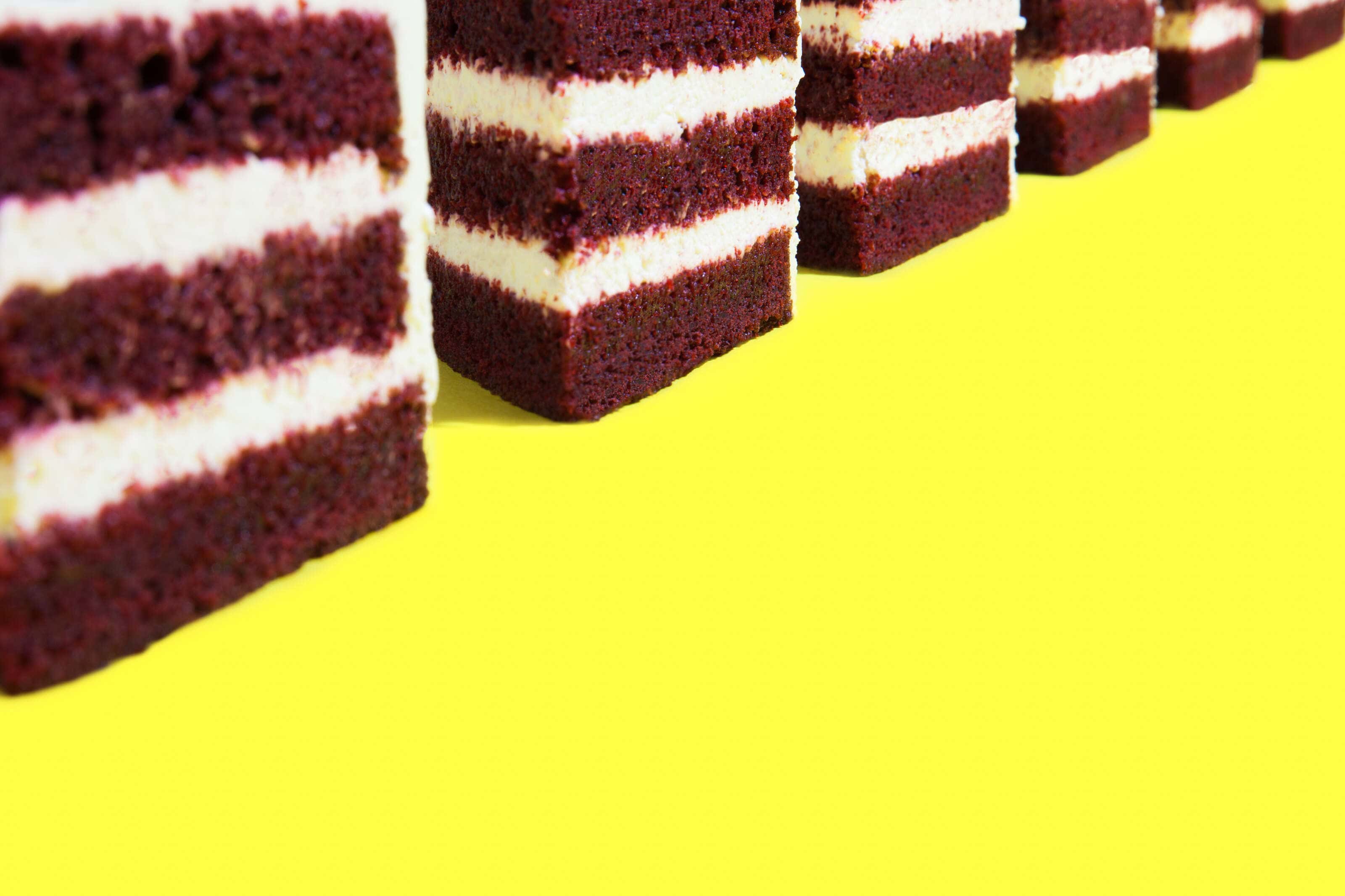 Red Velvet Cake photographed on a vivid yellow background in a Pop Art Style.