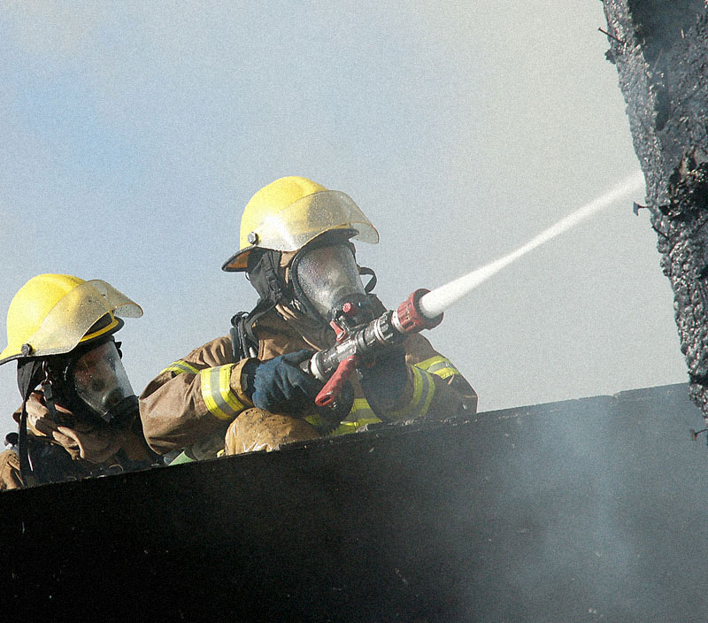 Pompier arrose un bâtiment