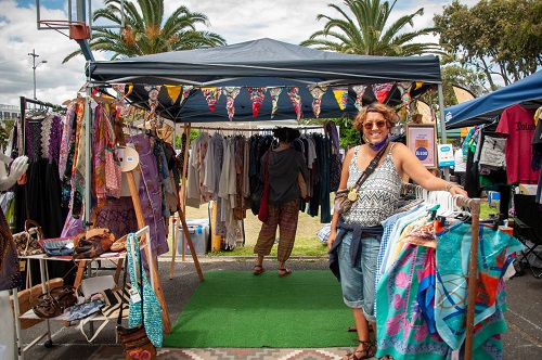 Stall owner posing in front of their clothing stall