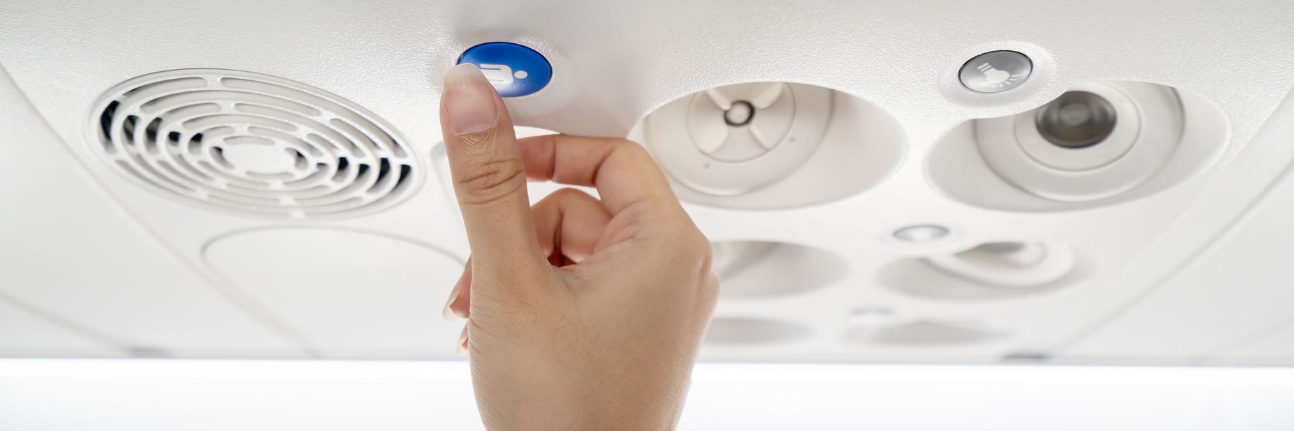 Passenger pressing overhead cabin call button