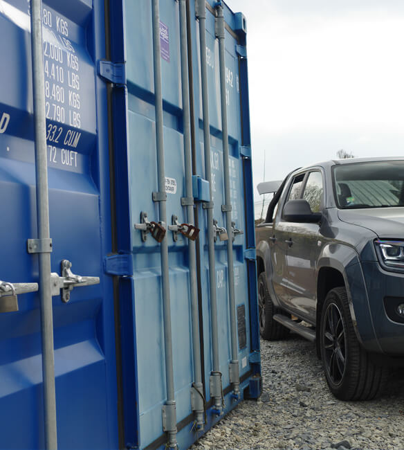 Storage container alongside parked car.