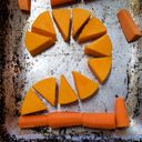 Chopped pumpkin and carrot in a baking tray forming a digit two