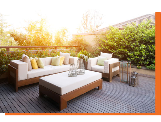 Beautiful outdoor furniture on a deck in a garden at sunset