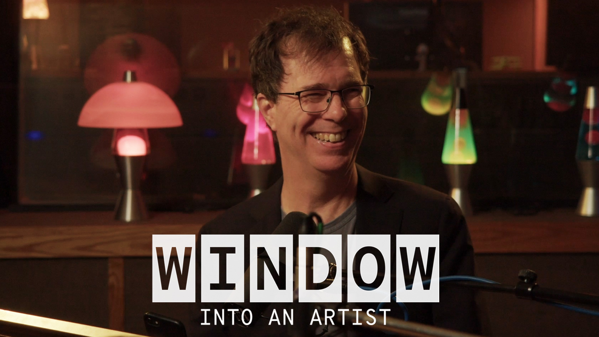 Ben Sings smiling in front of a mic with an overlay of text that reads ‘Window Into an Artist’