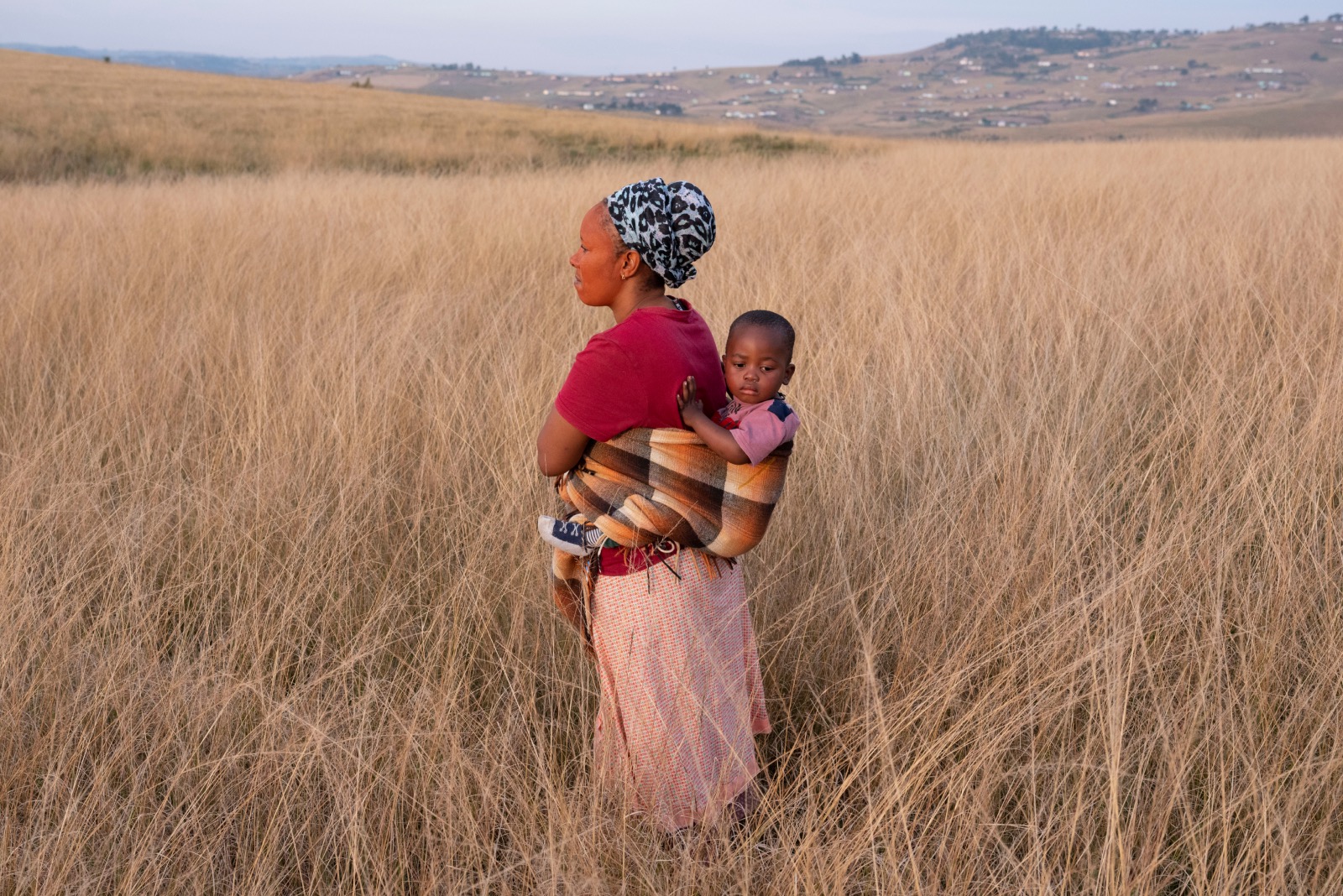mother carrying child in field