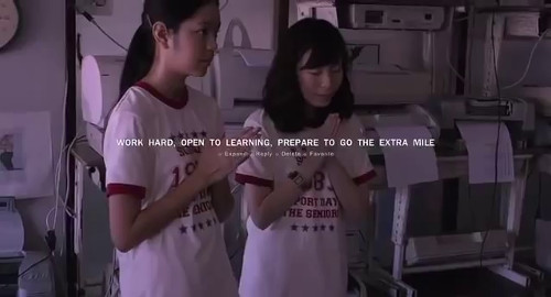 A screenshot of two girls in white and red school uniform t-shirts are praying. The caption reads 'Work hard, open to learning, prepare to go the extra mile'. From the film 'Mary is Happy, Mary is Happy'.