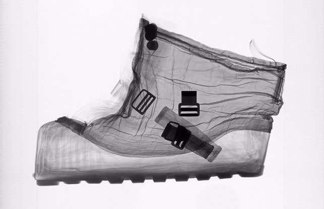 an x-rayed, transparent shot of a spacesuit boot, showing straps and buckles and the contoured curves where feet rest