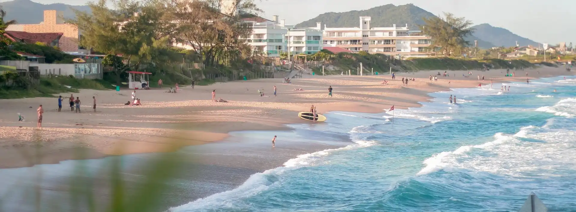 Vista da praia da praia do Morro das Pedras com mar azulado e banhistas na areia