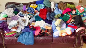 A huge pile of toques knitted by Humanity in Practice volunteers