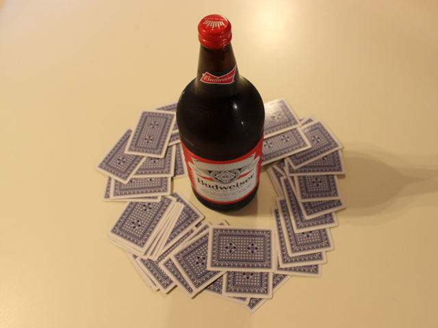 A game of King's Cup with the cards spread around a 40oz bottle of Budweiser beer