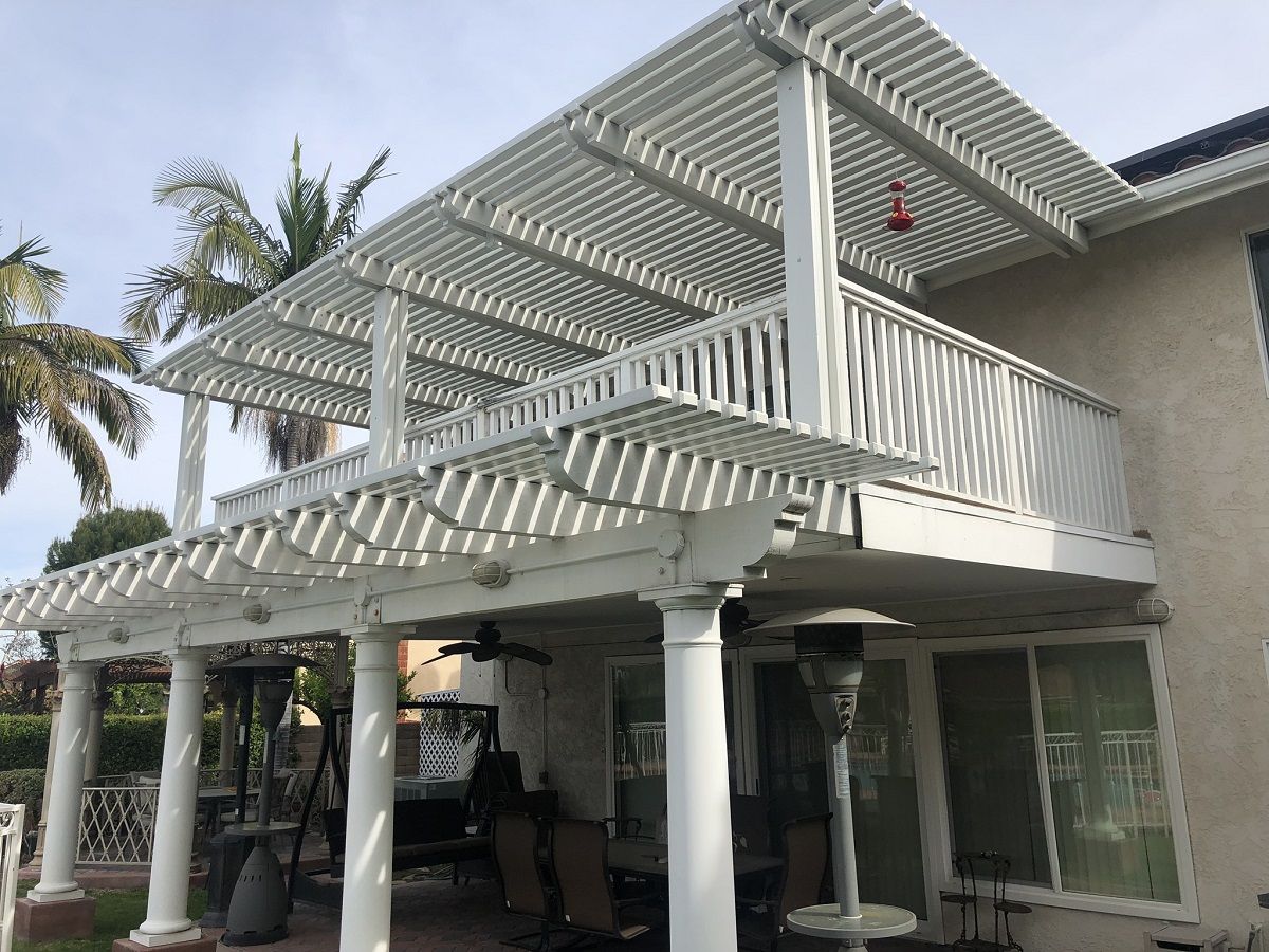 enlarged photo of white painted pillars holding a white painted deck that is covered by a white pergola
