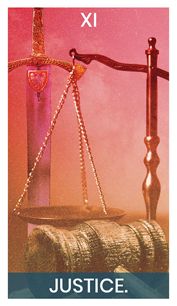 The Justice card. A sword, scales and gavel sit on a table.