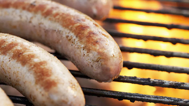 A set of delicious beer brats cooking on a grill for a Tailgate or Super Bowl party.