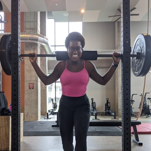 Lina lifting weights and smiling.