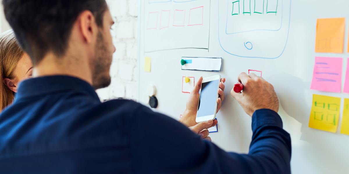 How to Get a Job in UX with No Industry Experience New designers working on a whiteboard prototype