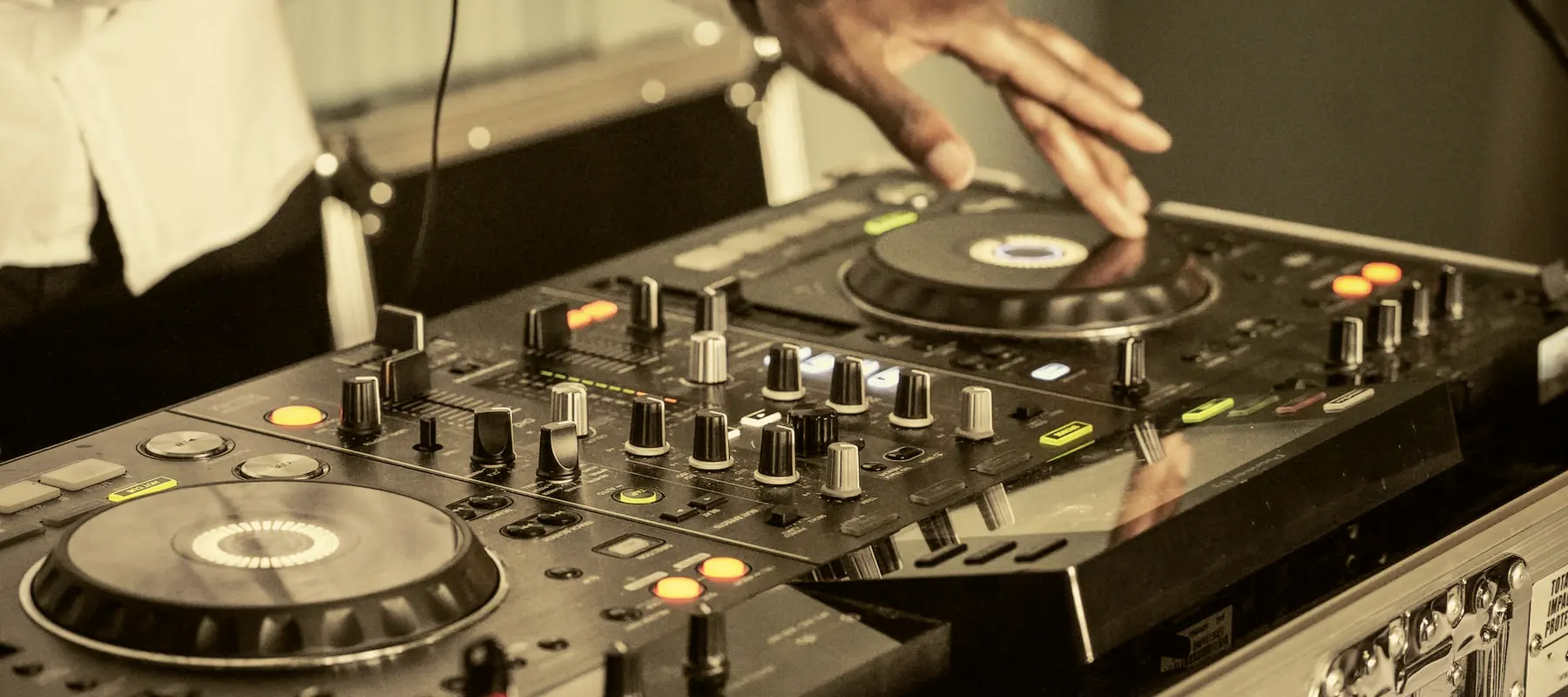 DJ operando seus equipamentos de som sobre uma mesa