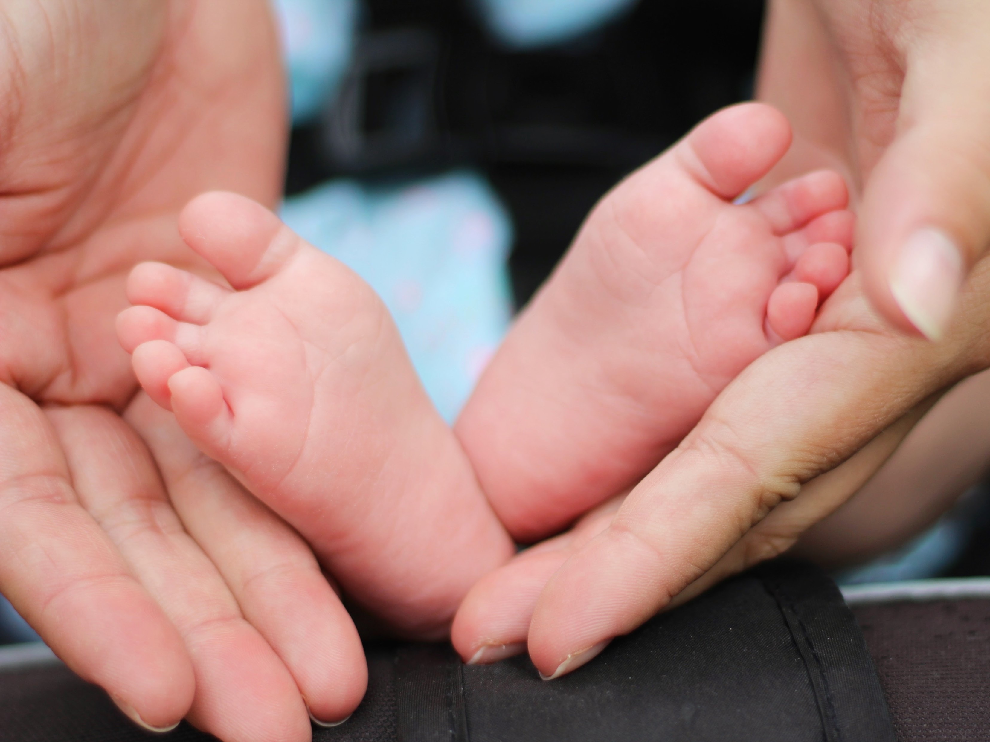 Adult hands holding a babies feet