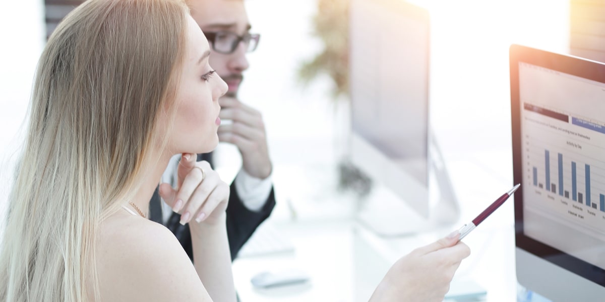 What is Bernoulli distribution? Two data analysts in side profile looking at a graph on a computer screen.