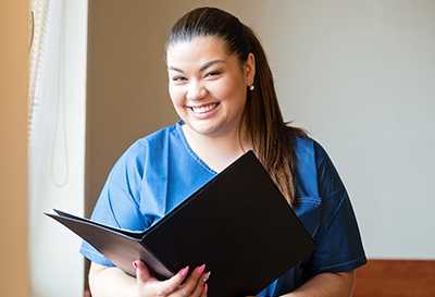 A healthcare professional smiles while reviewing notes