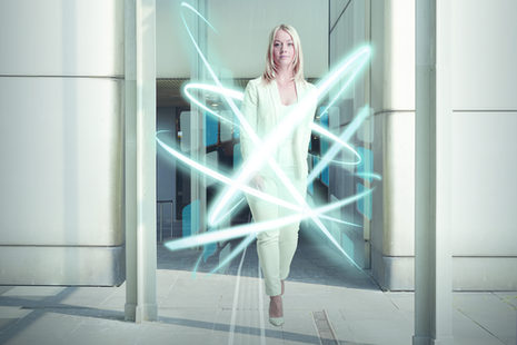 Eine Frau im weißen Anzug wird von leuchtenden Kreisen umgeben