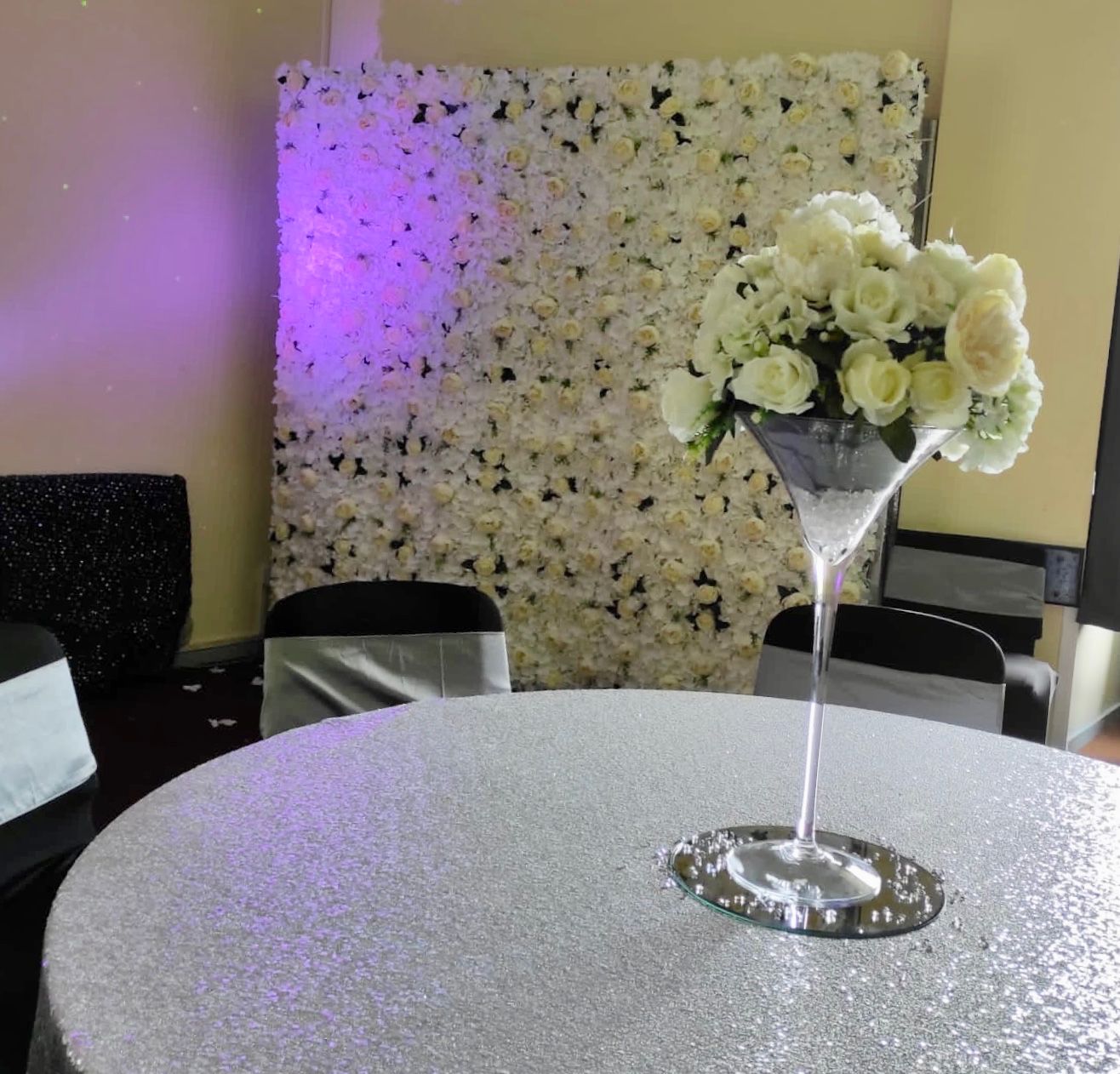 Lovely white flower wall in the background, with a white centrepiece in the foreground.