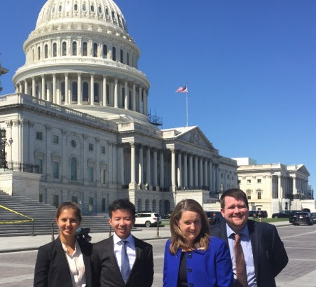 four advocates standing before the US Capitol, renovations nearly complete.
