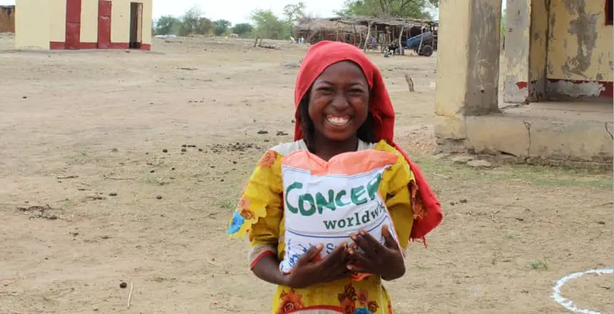 Young Sudanese girl collects seeds from a Concern Worldwide distribution