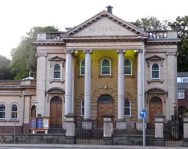 A grand, square building on a busy road