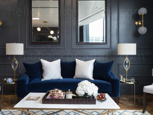 Classic yet modern meeting space containing luxurious blue sofa and white coffee table infront of interior window  Microsoft Teams background