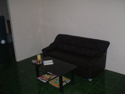 Wir betreten das ehrwürdige Gemäuer durch die hölzerne Vordertür und sehen uns dem Medienzimmer gegenüber. Die thailändische Standardcouch fehlt ebensowenig wie das in allen Häusern vorhandene Glascouchtischmodell (identisch mit dem im alten Haus --- man vergleiche bitte). Auf dem Tisch sehen wir ein Buch mit einem pinken Elefanten sowie verschiedene Drogenbestecks. Einige neckisch verteilte Sessel vervollständigen das noch recht karge Ambiente und geben zwischen durch einen Holzmarionettenelefanten namens Kah (Hubert Kah) bewachten Fernseher und Couch den Weg in die Partyhalle frei.
Die Partyhalle glänzt durch noch zu verplanende Mehrzweck-Leere, einen Kühlschrank und einer fest in den Boden eingemauerten Spüle unter der sich gar trefflich verschiedene Müllsorten verbergen lassen. Im Hintergrund sehen wir das Spa Beddig, in das wir aus Pietätsgründen nur kurz einen Blick werfen wollen.
Das Spa glänzt durch organisierte Gestaltung und charmante Fliesierung. Beachten Sie bitte die Feuchtigkeitscreme mit UV-Schutz sowie den allgegenwärtigen Jacko-Zerstäuber. Im Spiegel erkennt der geneigte Betrachter einen durch verschiedene Ereignisse in naher und ferner Vergangenheit verschlankten Autoren der die Wirkung des Blitzes geschickt zur Verwirrung des Blickes zu nutzen weiß.
Gehen wir weiter zur Spielwiese:
Sehen Sie das geräumige Bett, das geradezu auf Belegung wartet sowie die verschiedenen Fenster die nach draußen führen. Ein kleiner Schrank lädt zum Verweilen ein.
Und nun noch eine Außenansicht des Komplexes:
Beachten Sie bitte das erfahren platzierte Moped, es zieht sich wie ein roter Faden durch die schreiBBloga.de!
Vielen Dank für Ihren Besuch und kommen Sie bloß nicht wieder. Es sei denn, Sie bringen ein Geschenk mit. Danke.